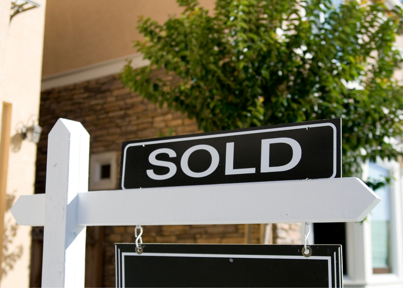 Sold sign on top of a real estate sign