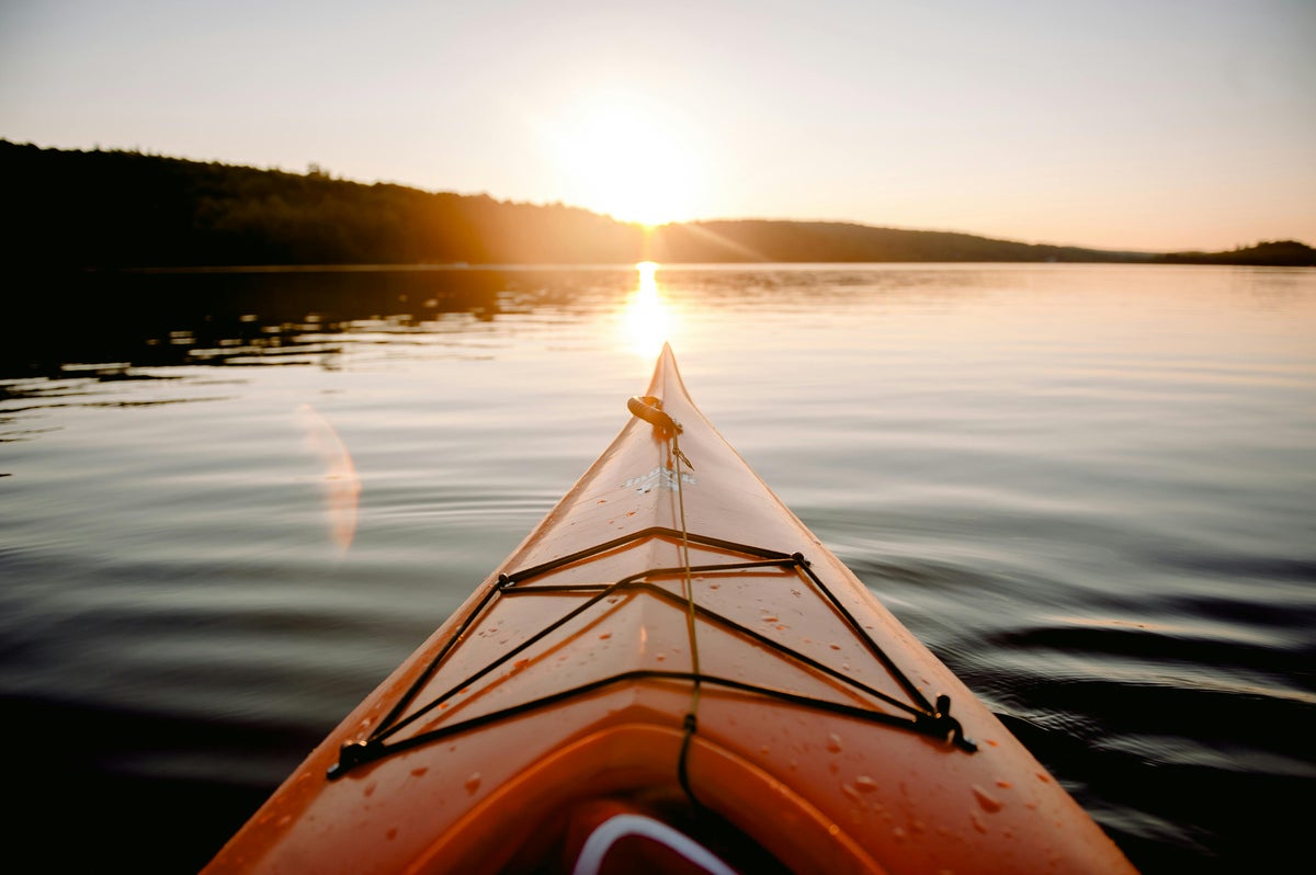 Kayak on a calm lake at sunset in Fall River Nova Scotia with warm evening light reflecting on the water