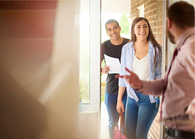 REaltor inviting people into an open front door
