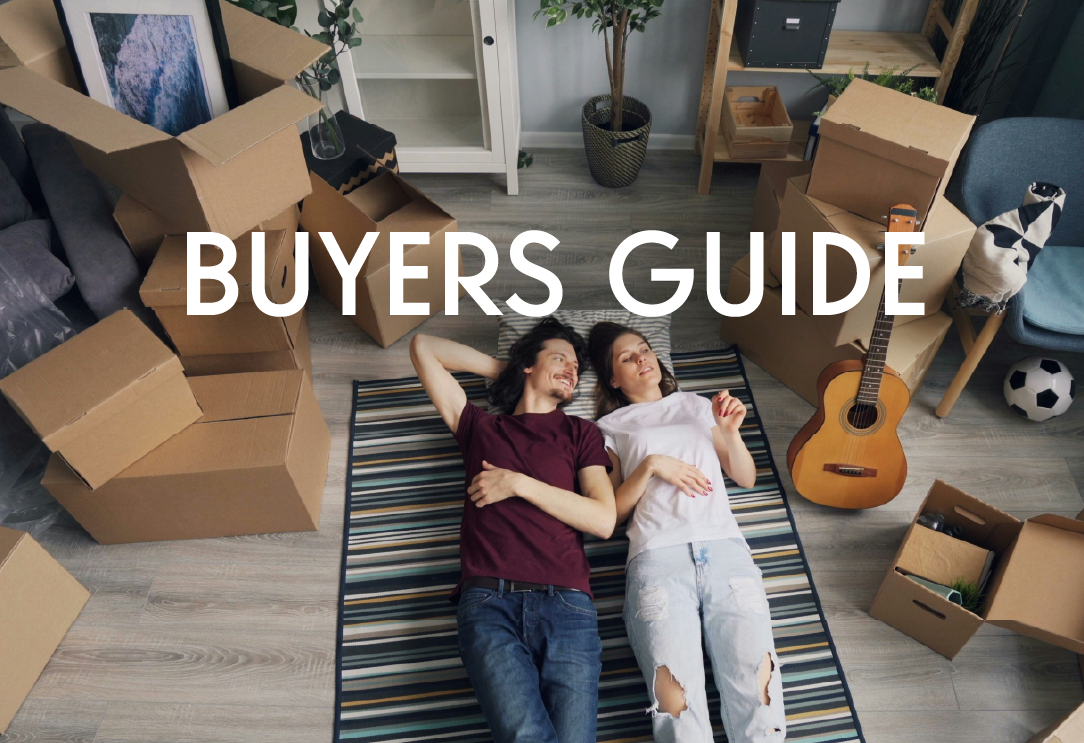 a young man and woman laying on a floor surrounded by moving boxes