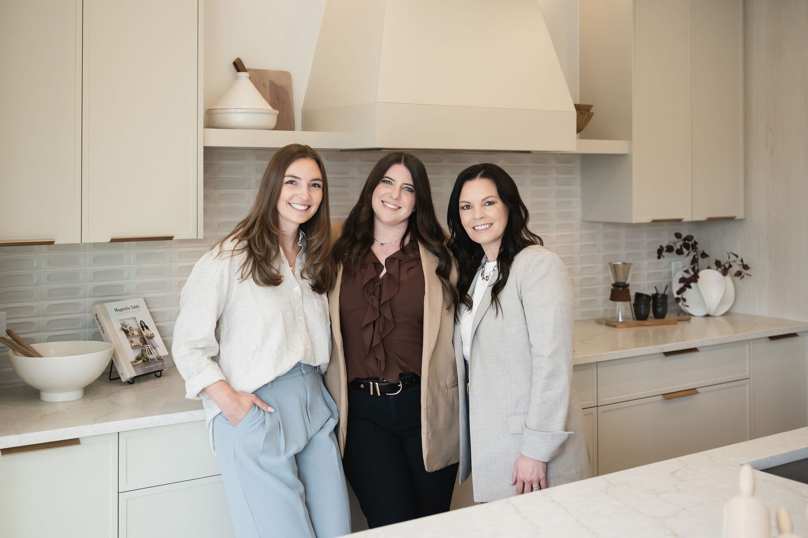 Jenna Bole Real Estate Team members Jenna Bole, Crystal Jepp and Julia Barrett sitting on a couch in a listing they have sold