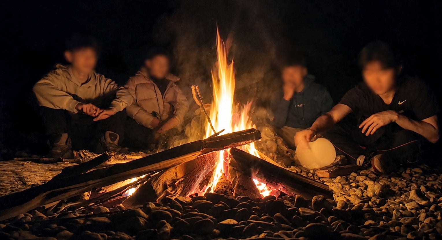 Wilson Chiu and Scouts Canada youth members gathered around a campfire during an outdoor camping trip