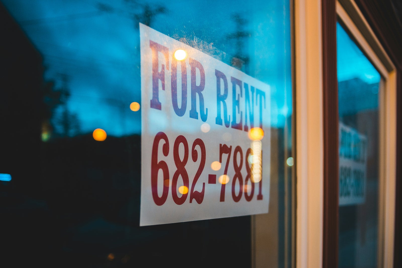 For rent sign displayed in a window, representing the ongoing cost of renting compared to homeownership.