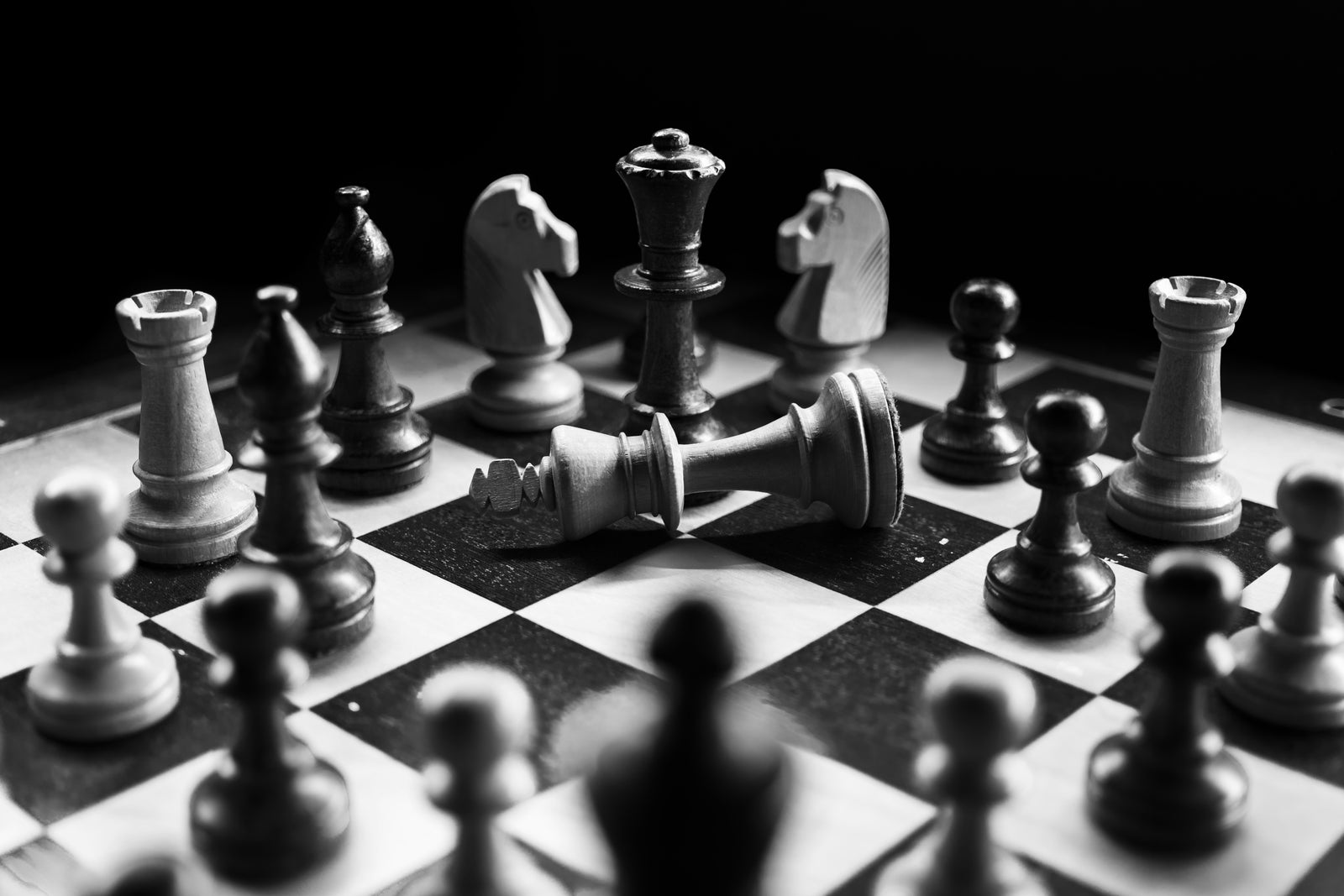 Fallen king on a chessboard representing the risks of overpricing your home and poor home pricing strategies when selling.