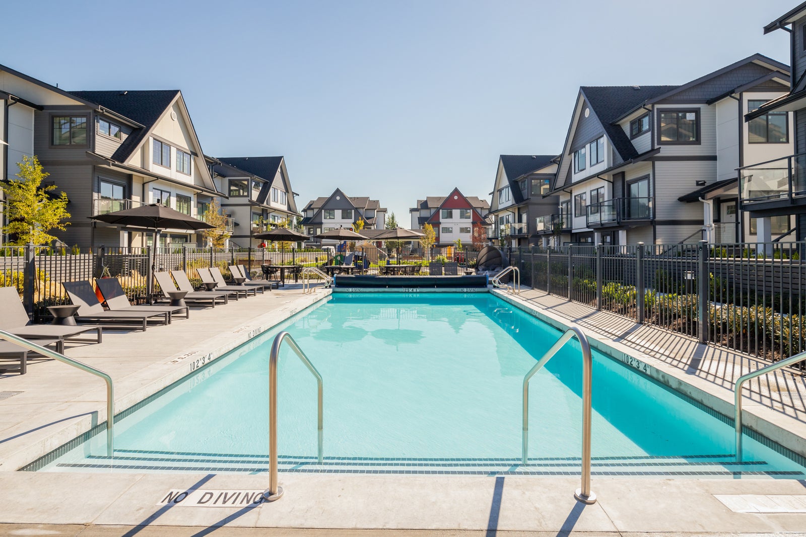 Outdoor pool and lounge area at Nature’s Walk townhomes in Pitt Meadows BC