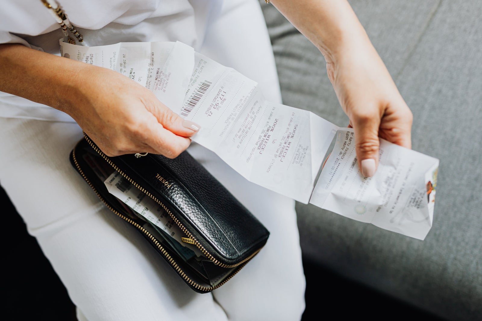 Homeowner reviewing receipts and expenses, representing the ongoing costs of homeownership beyond the purchase price.