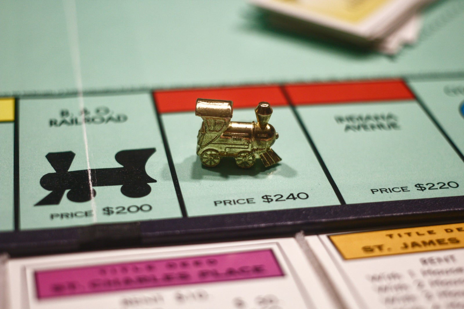 Monopoly train piece on a board representing decision making when buying or selling a home first.