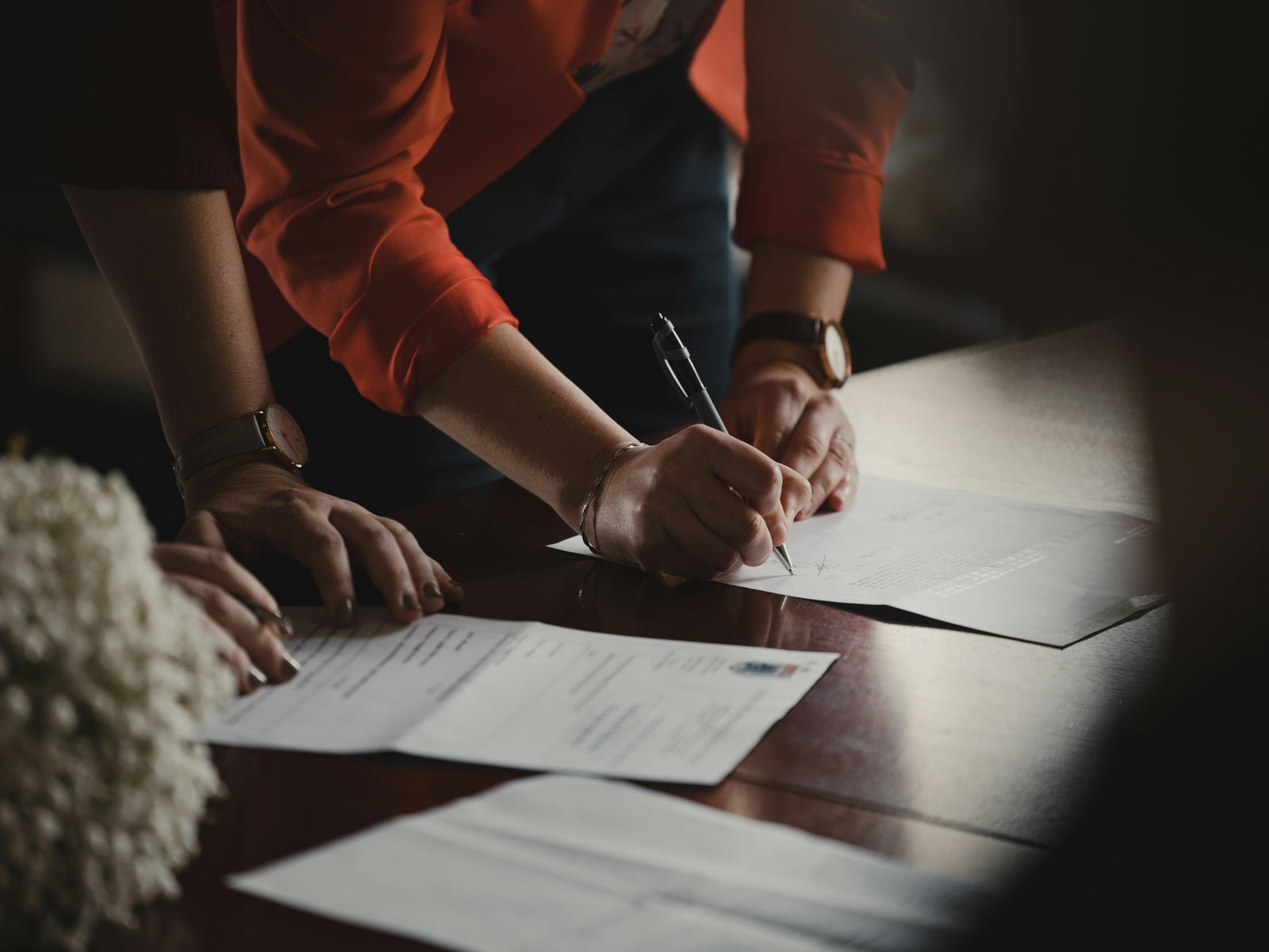 People signing legal documents representing property disclosure requirements in BC real estate transactions.