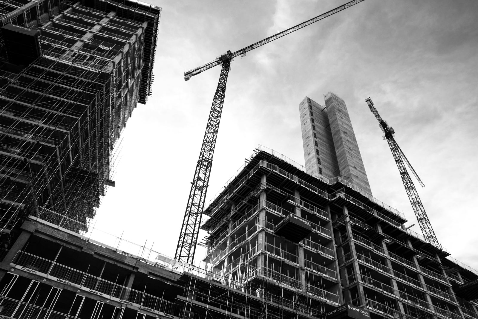 High-rise residential construction cranes representing new housing development and government support for stalled projects.