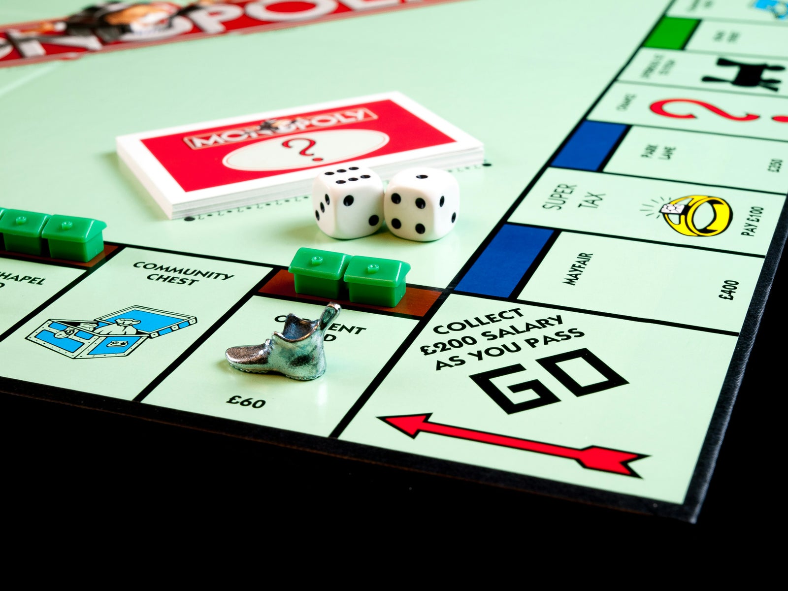 Monopoly board with dice and cards representing the risks and timing of buying or selling a home.