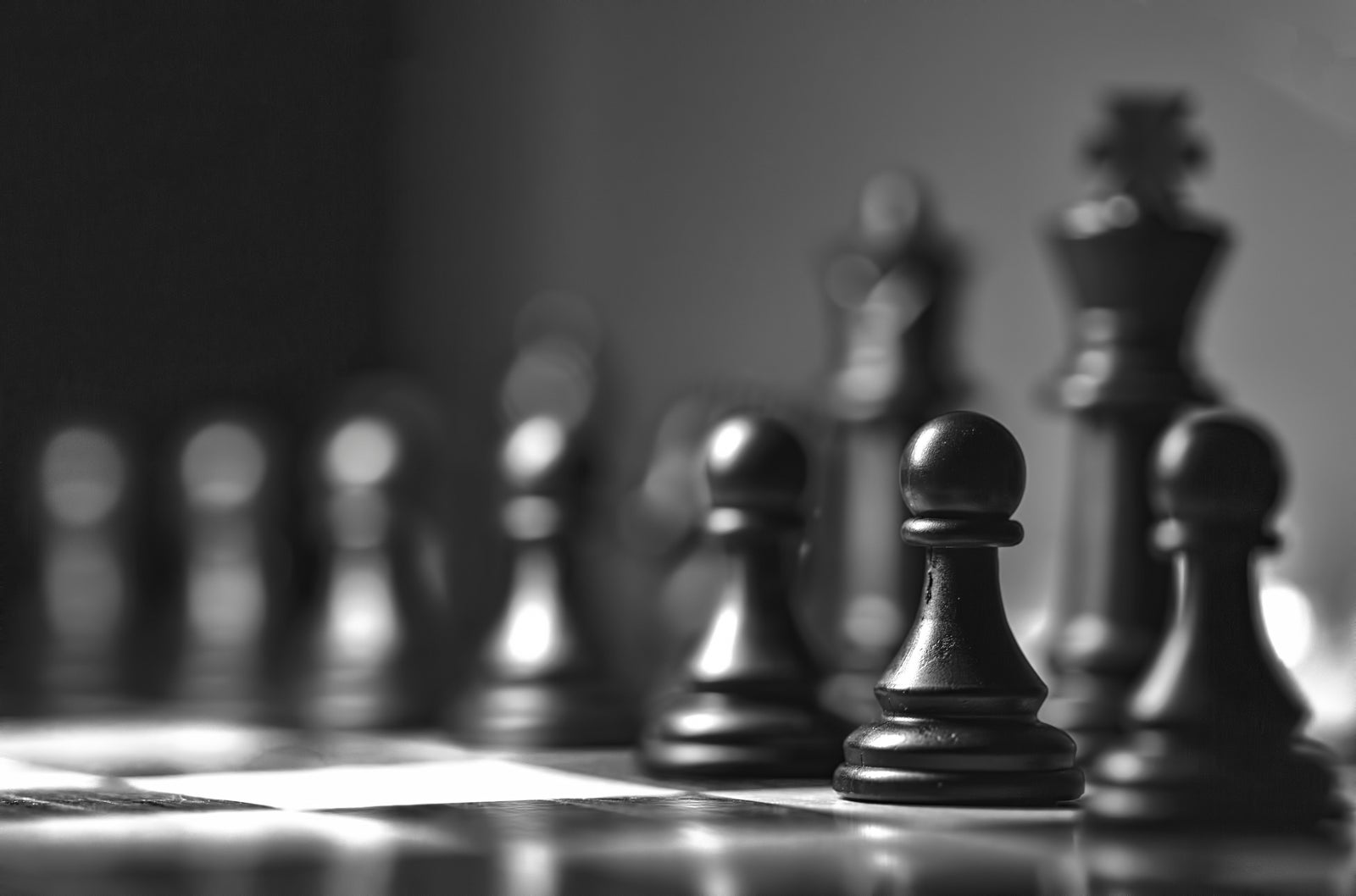 Chess pieces on a board representing the strategic planning behind choosing the right home pricing strategy to maximize your sale price.