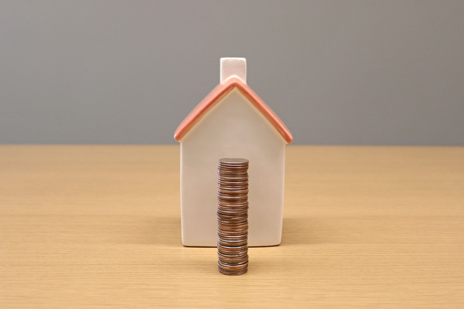House model with a stack of coins representing home equity as a retirement asset for Canadian homeowners.