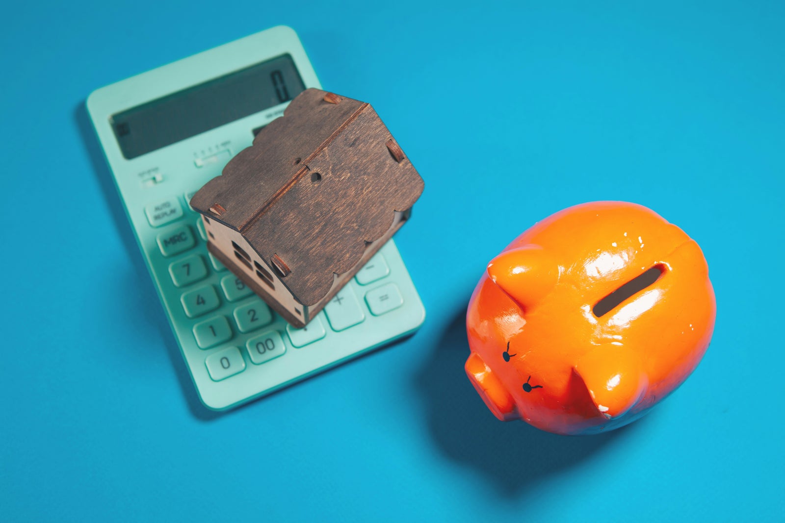 House model, calculator and piggy bank representing home equity, retirement savings and long-term financial planning for homeowners.