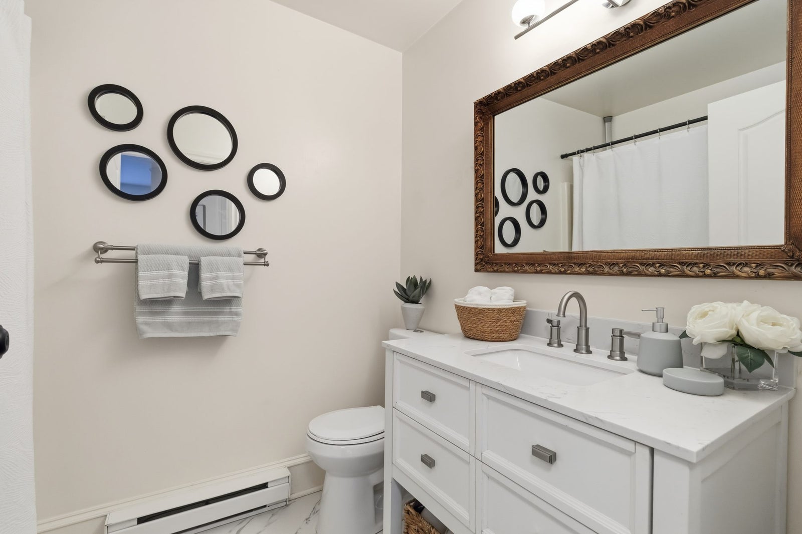 Updated bathroom with white vanity, stone look counter and brushed nickel fixtures in a Victoria BC townhouse