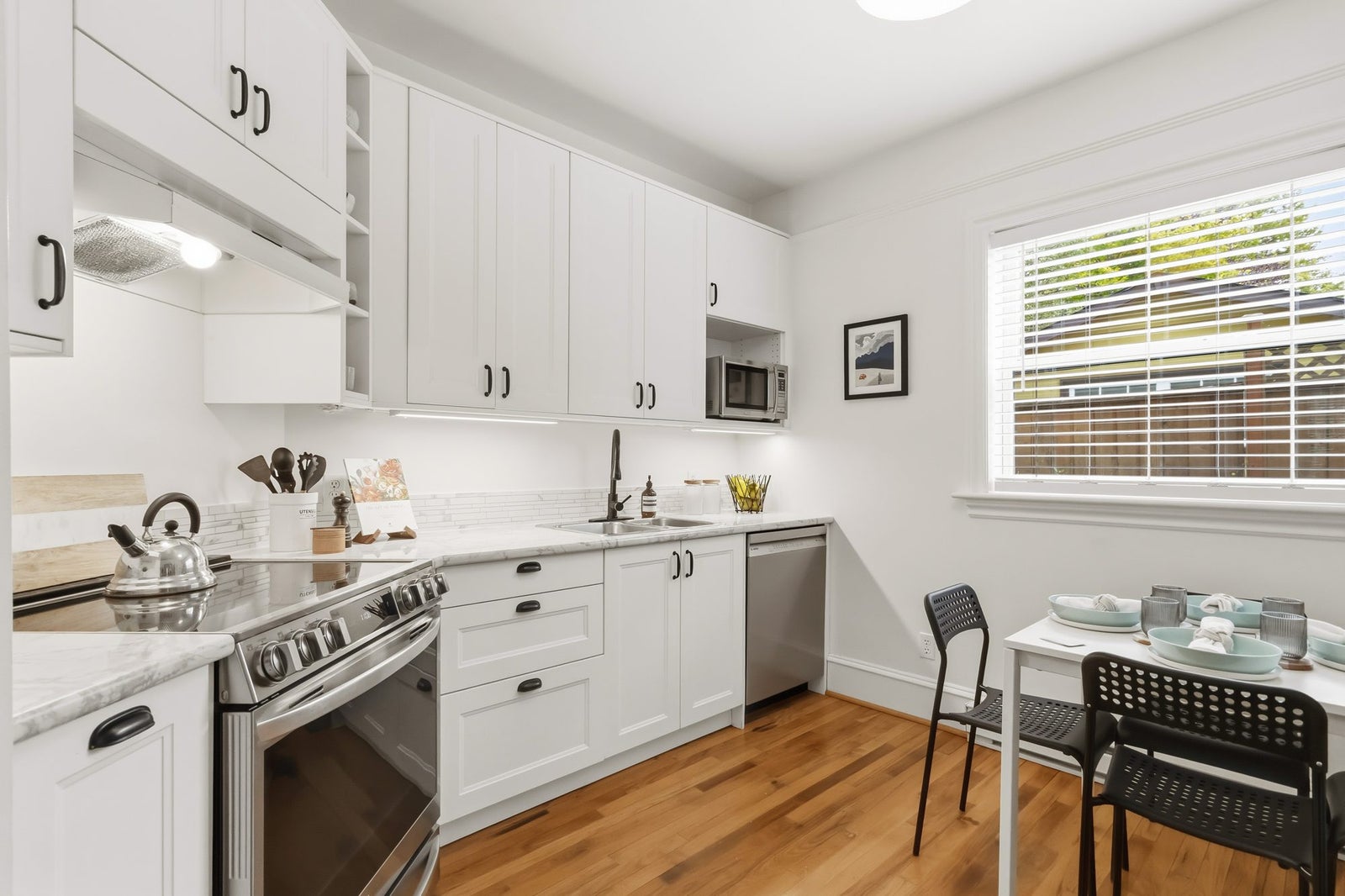 Kitchen eating area with window and stainless steel dishwasher at 1353 Grant Street, Victoria BC