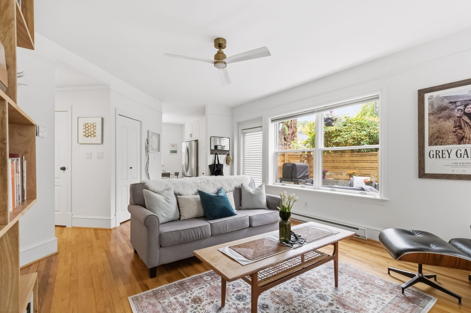 Bright living room with oak floors, ceiling fan and large windows in a Fernwood townhouse