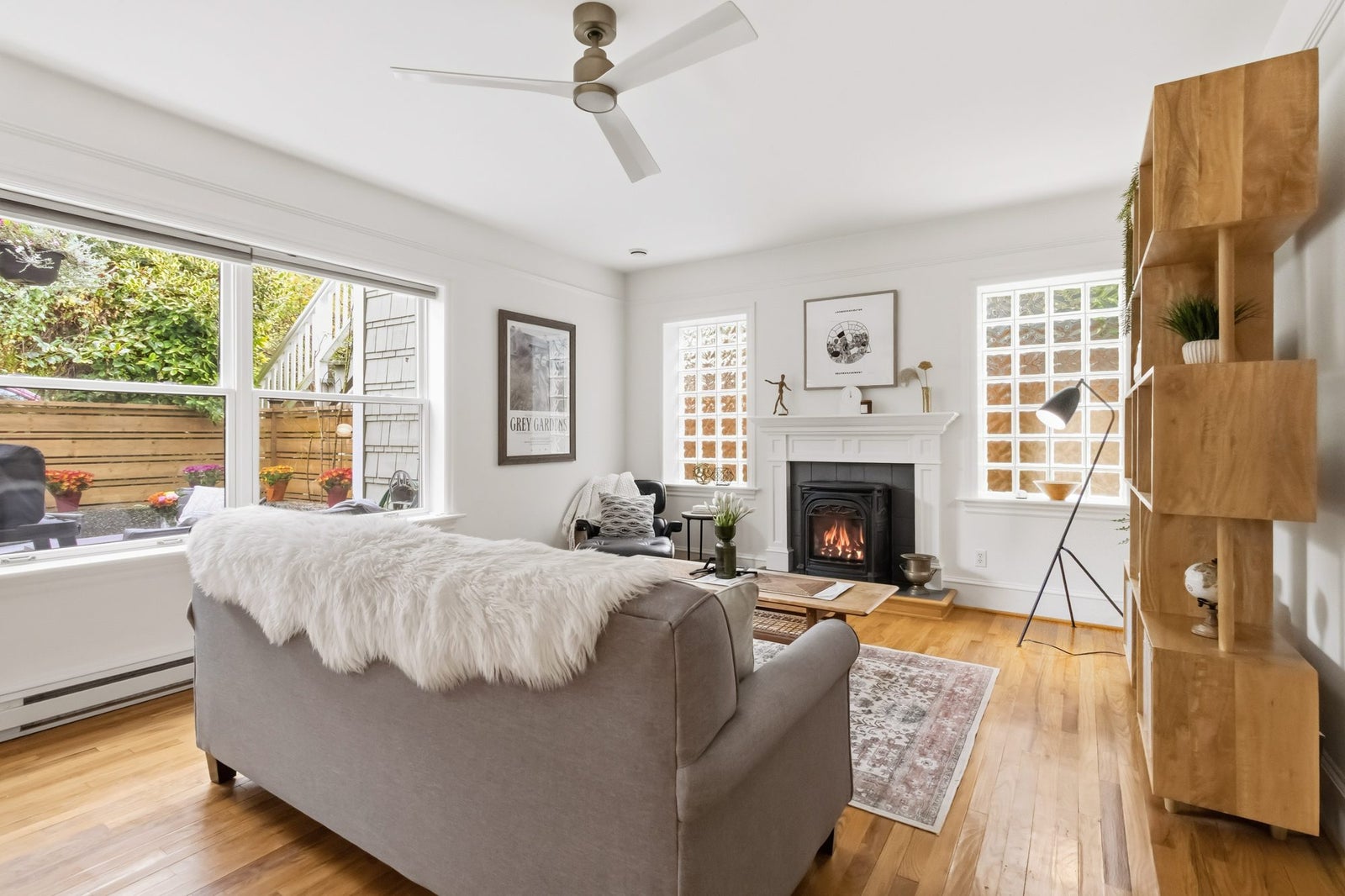 Living room with gas fireplace, white mantel, glass block windows and oak floors at 1353 Grant Street, Fernwood