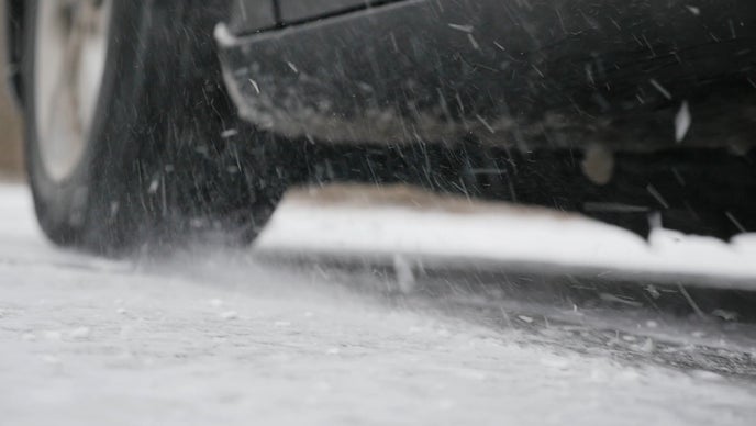 Winter tires on car driving through snowy road