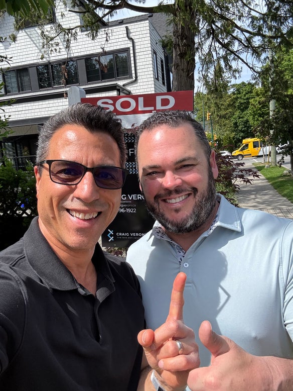Happy clients holding Just Sold sign in North Vancouver