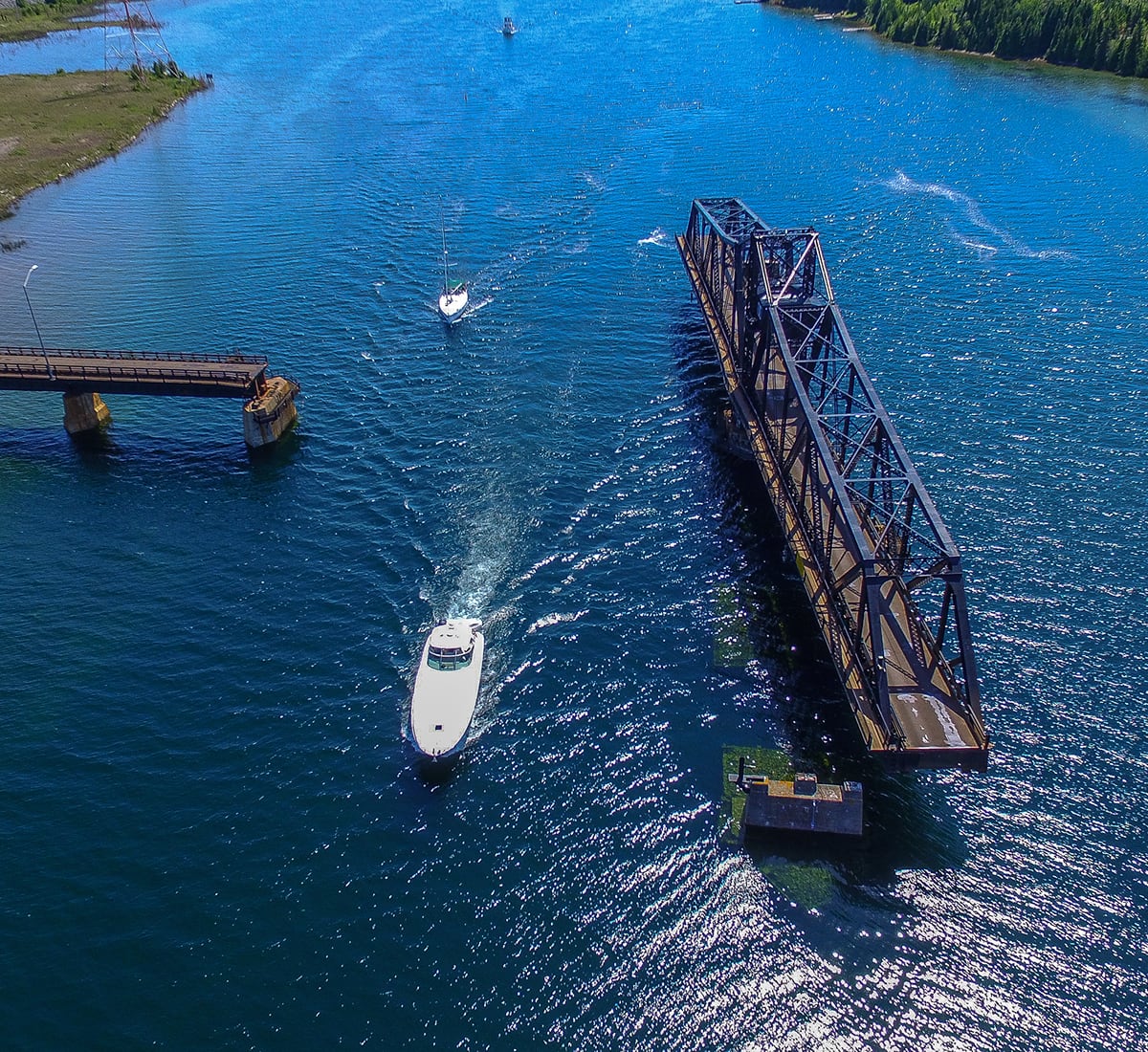 Cruising boats on the North Channel passing open Swing Bridge in Little Current, Manitoulin Island