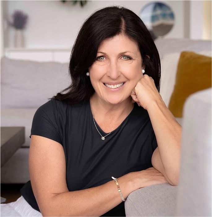 Nanoose Bay photo coach Deanna Johnson smiling while seated on a sofa.