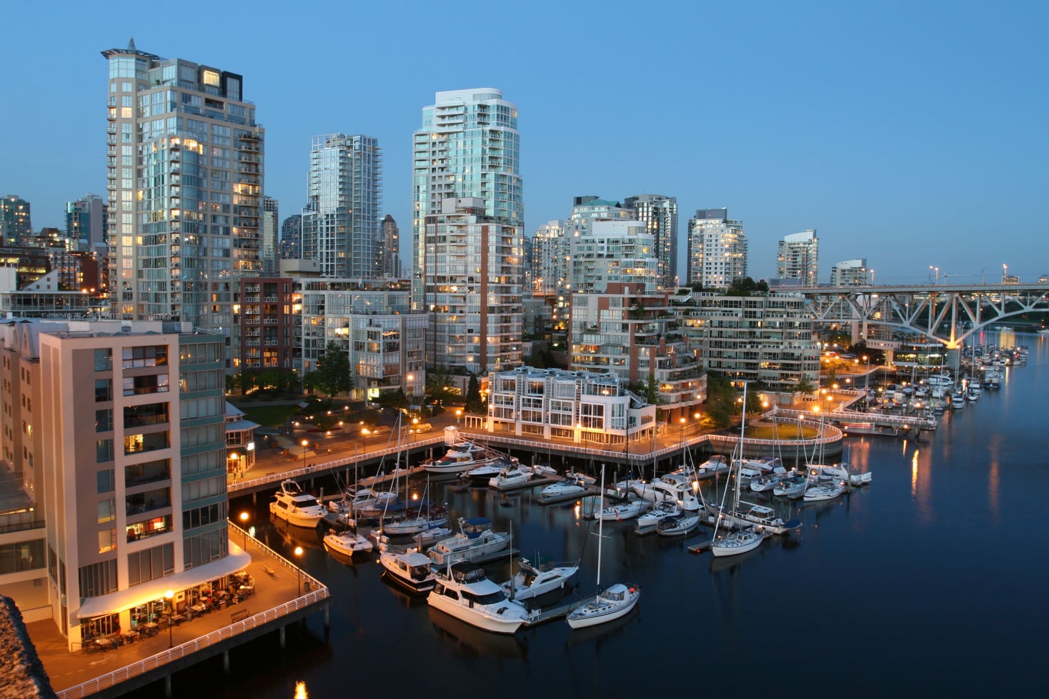 Evening view of Yaletown waterfront with luxury condos and a marina, showcasing prime Yaletown real estate options for potential buyers working with a Yaletown realtor.