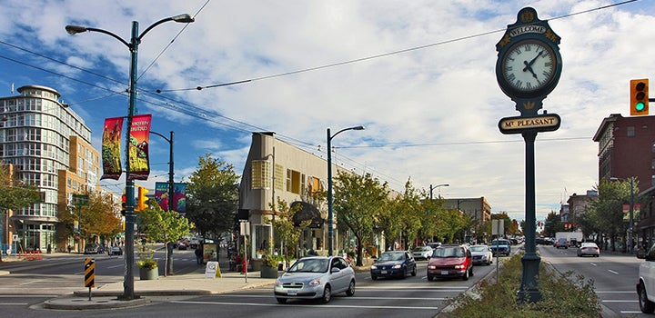 A vibrant street scene in Mount Pleasant, Vancouver, showcasing a mix of modern condos and local businesses, ideal for exploring Mount Pleasant real estate opportunities.