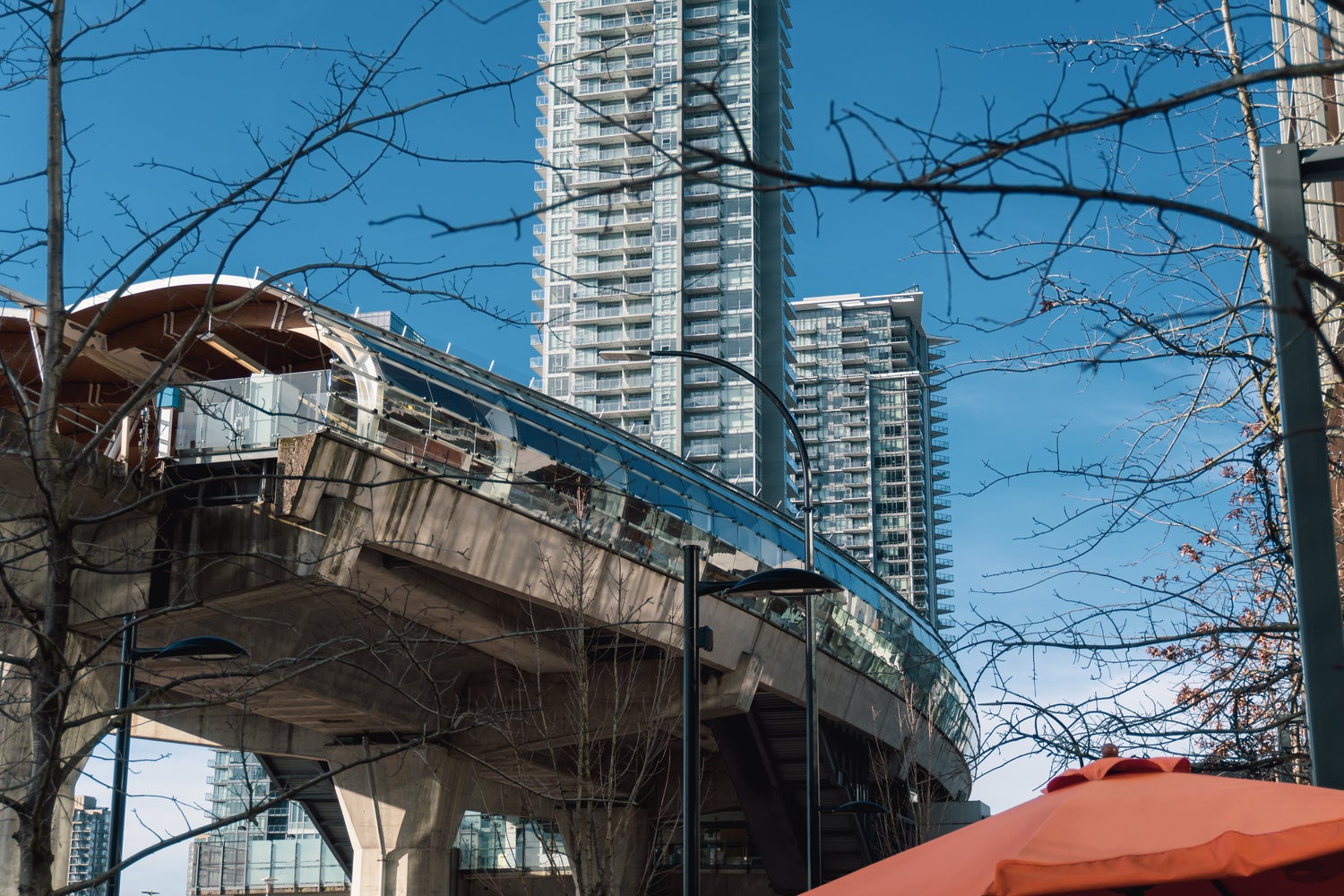 Close-up view of Brentwood SkyTrain station with high-rise condos in the background, illustrating the convenience of Brentwood real estate for commuters