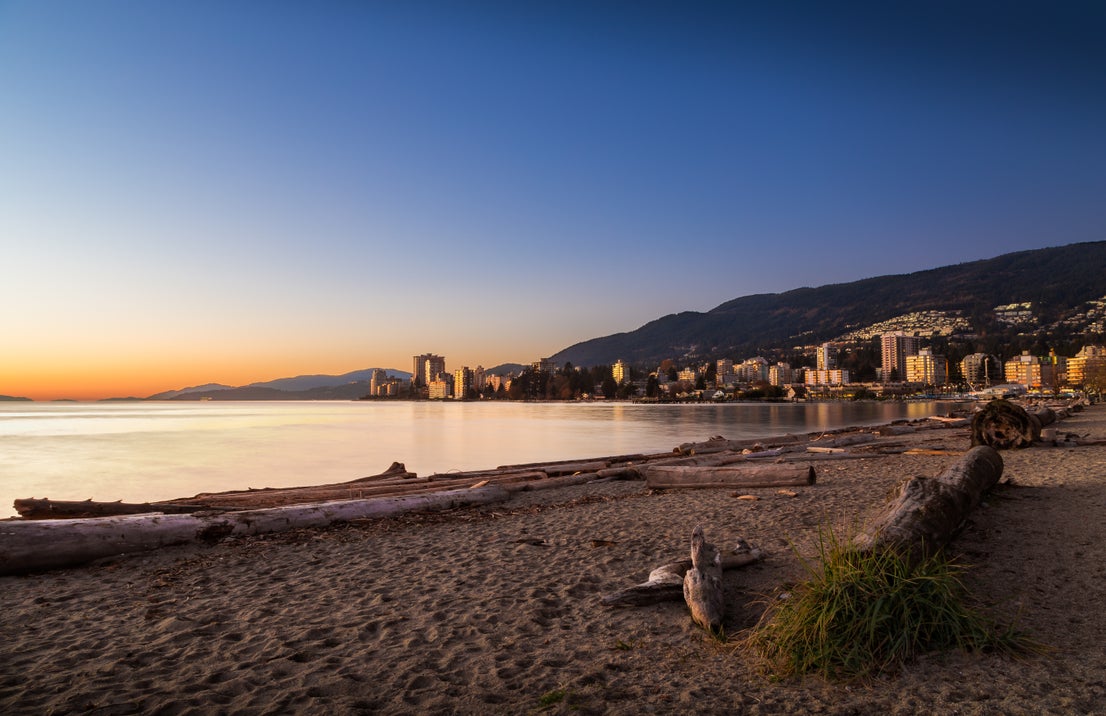 Scenic sunset view of West Vancouver's waterfront and residential buildings, showcasing the area's prime real estate options