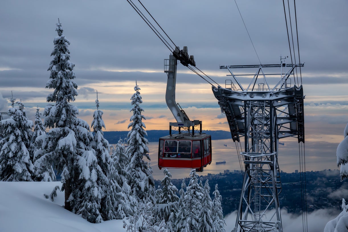 Winter view of Grouse Mountain gondola with snow-covered trees, overlooking North Vancouver real estate and waterfront