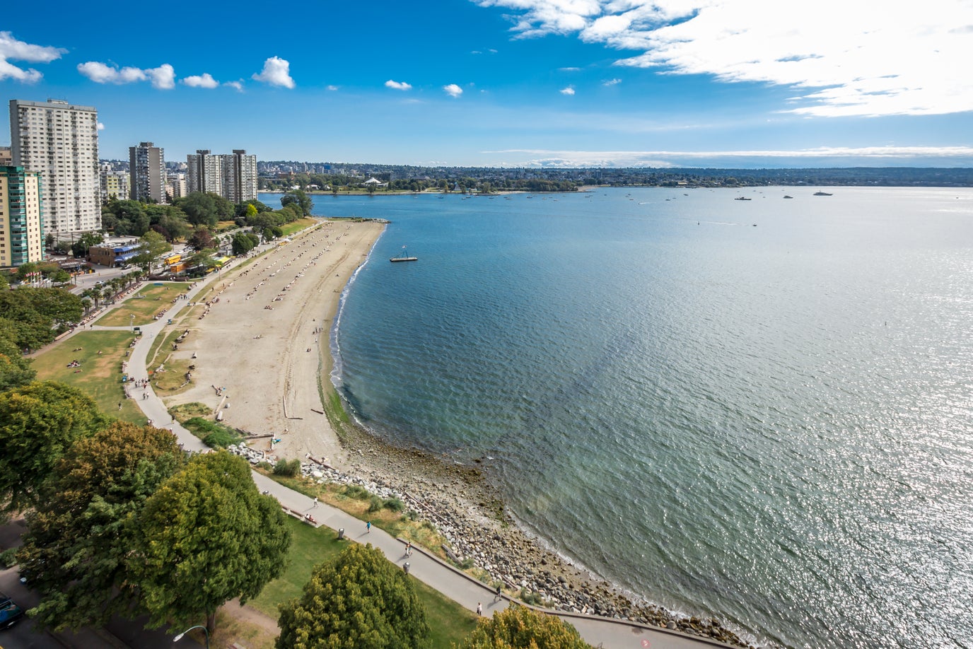 Aerial view of Vancouver's English Bay beachfront and surrounding high-rise buildings, showcasing prime real estate opportunities in Downtown Vancouvers West End neighbourhood.