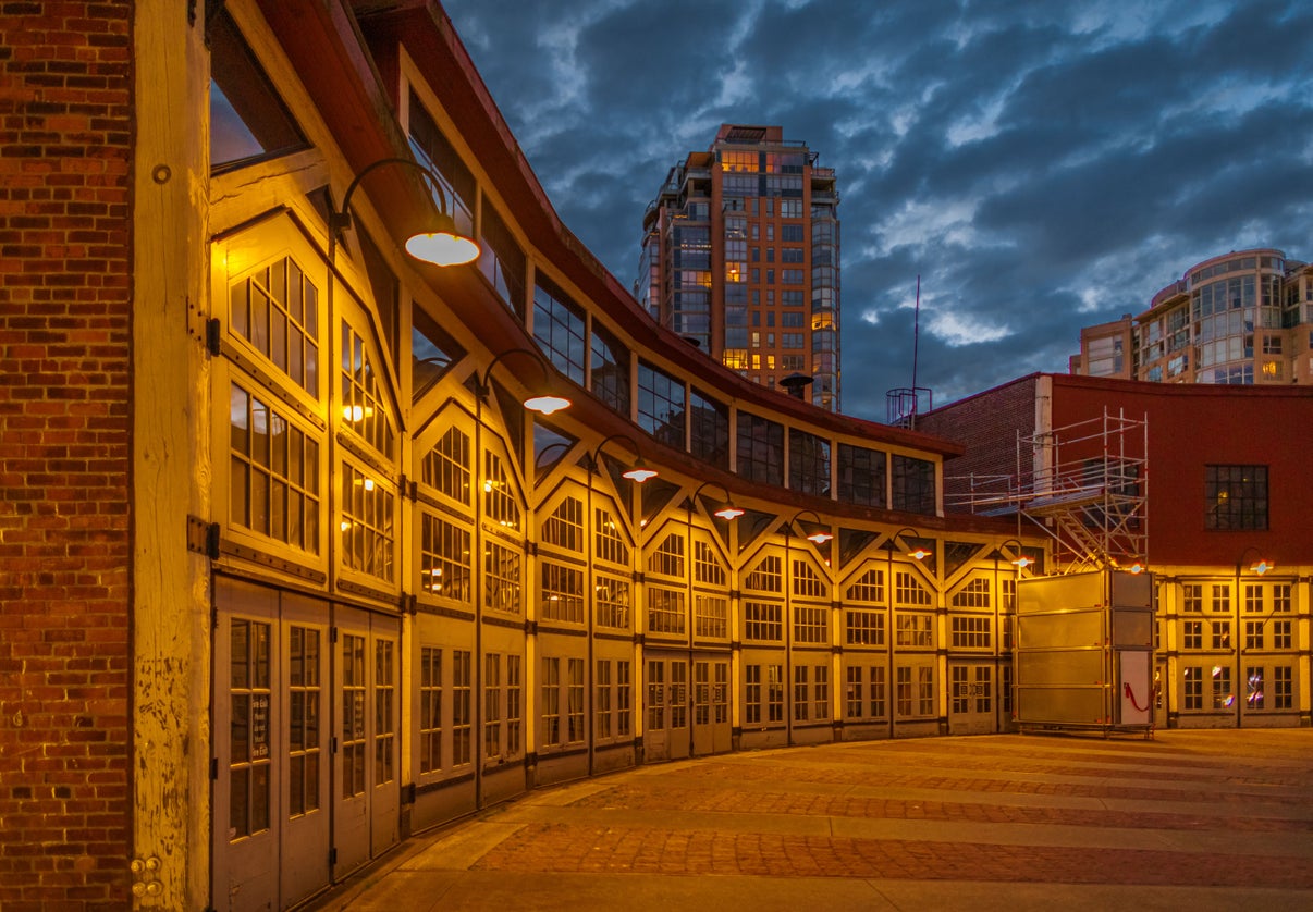 Historic Yaletown building with illuminated windows at dusk, showcasing nearby Yaletown condos for sale and modern living options with a Yaletown realtor.