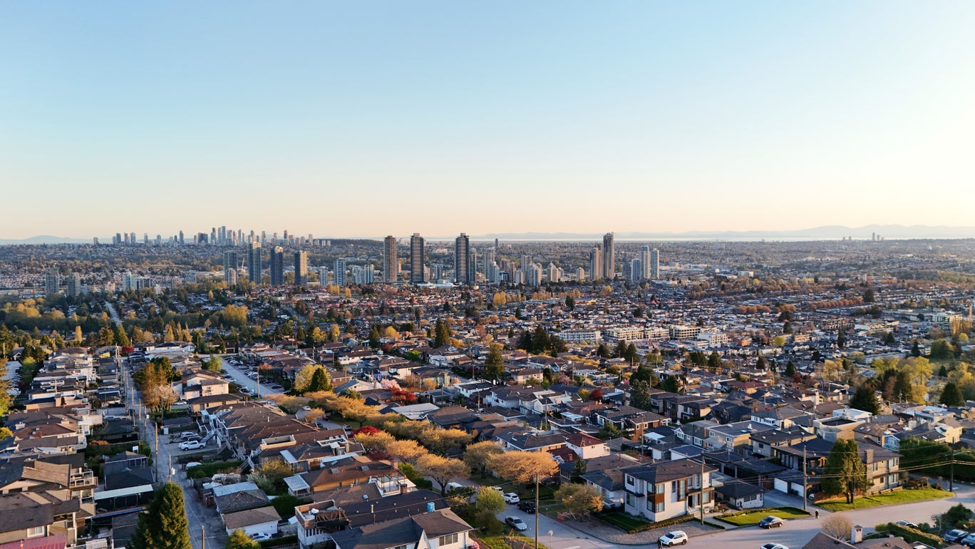 Aerial view of Burnaby's residential neighbourhoods and high-rise buildings at sunset, highlighting diverse real estate options in the city.