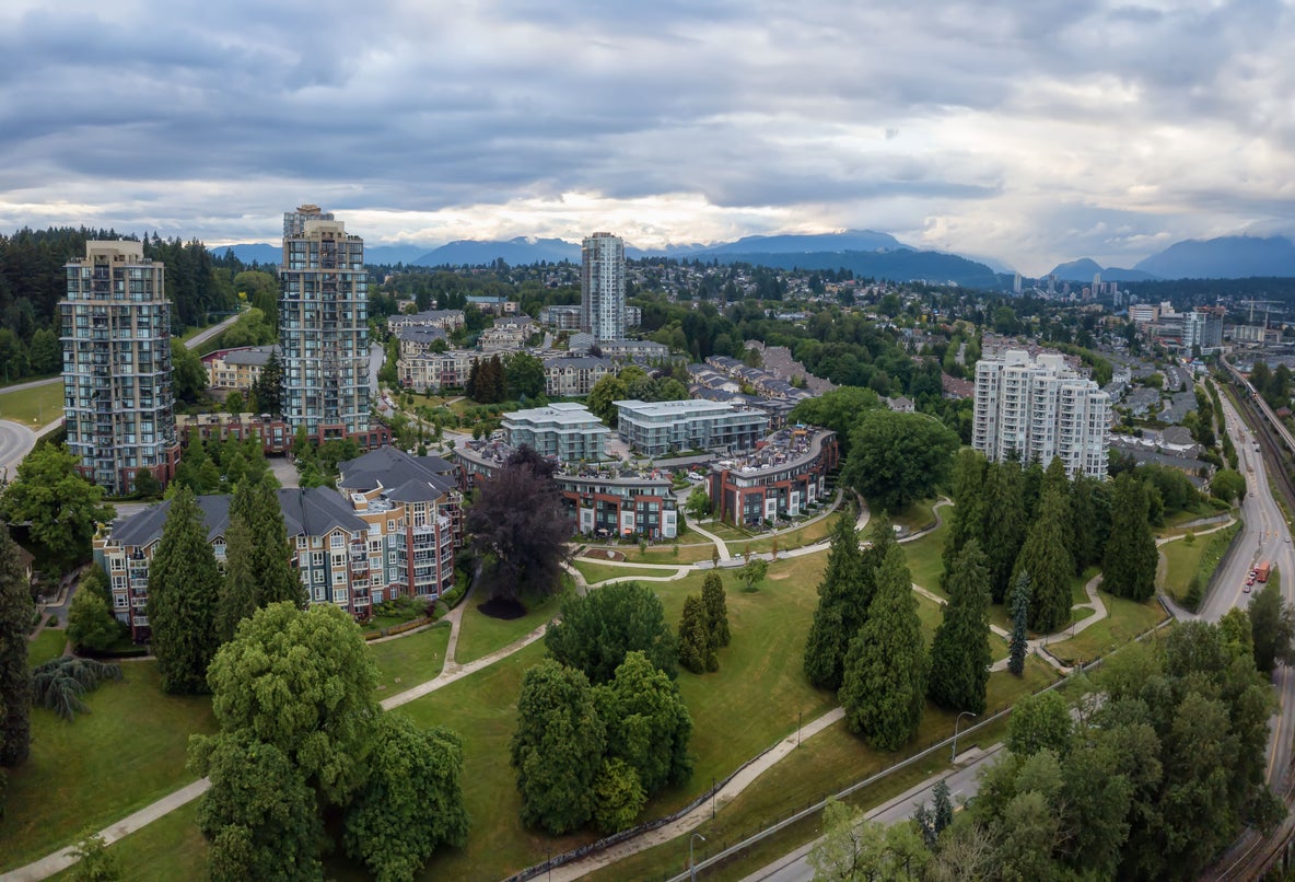 A panoramic view of New Westminster real estate showcasing modern high-rise condos and lush green spaces, ideal for buyers seeking a new home. Find your property with a trusted New West realtor.