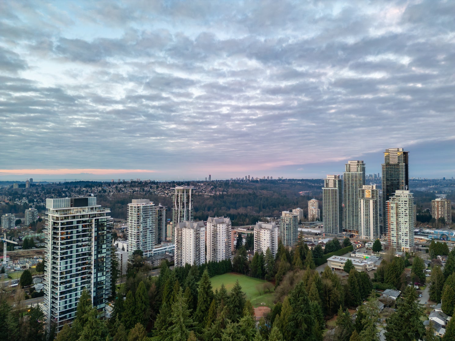 Aerial view of Coquitlam's cityscape, featuring modern high-rise buildings and green spaces, highlighting vibrant real estate opportunities in the area