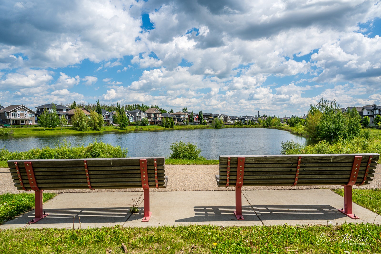 two park benches overlook a serene view of the Erin Ridge North storm water pond