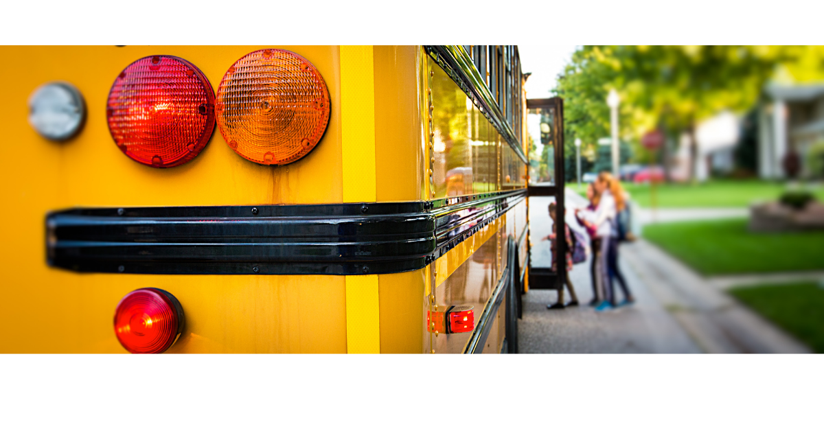 Back of school bus with children boarding