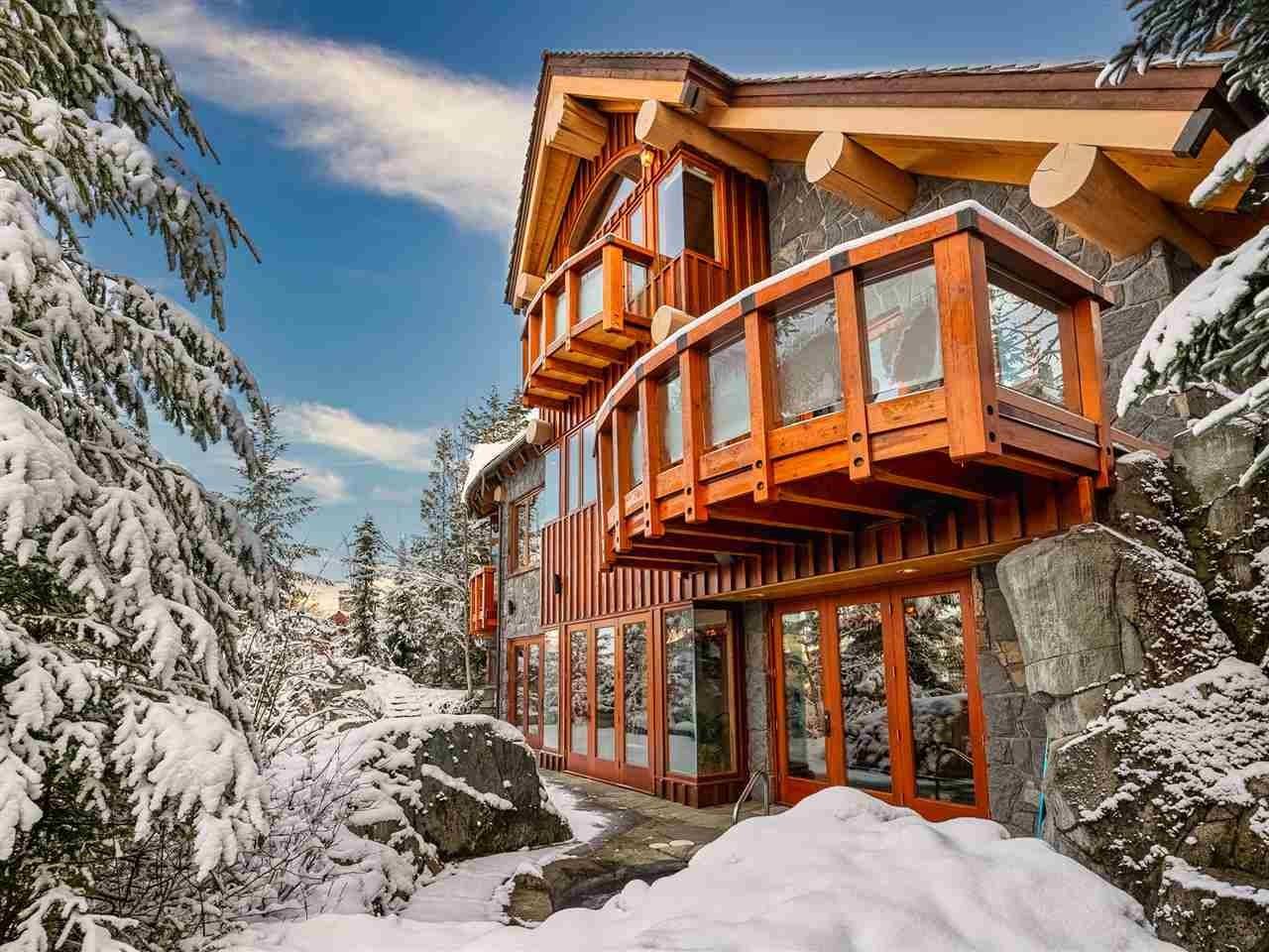 Large cabin-design home in a snowy, forested setting.