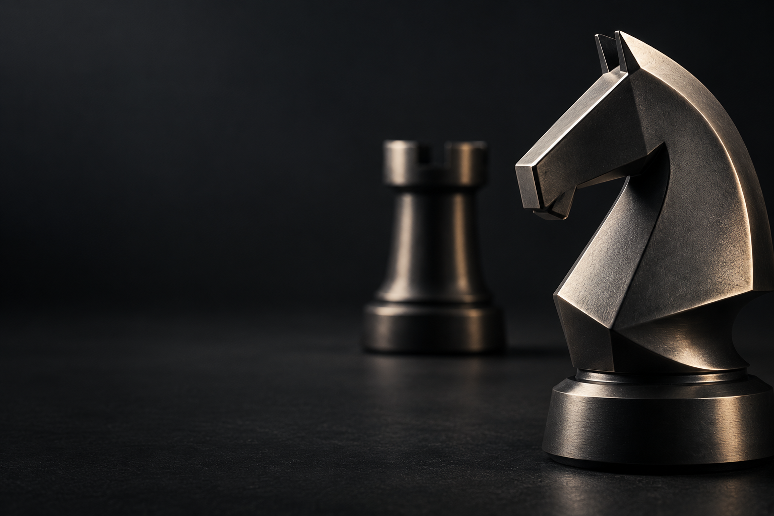 A sculptural graphite chess knight in sharp focus, with a second piece softly visible beyond it.