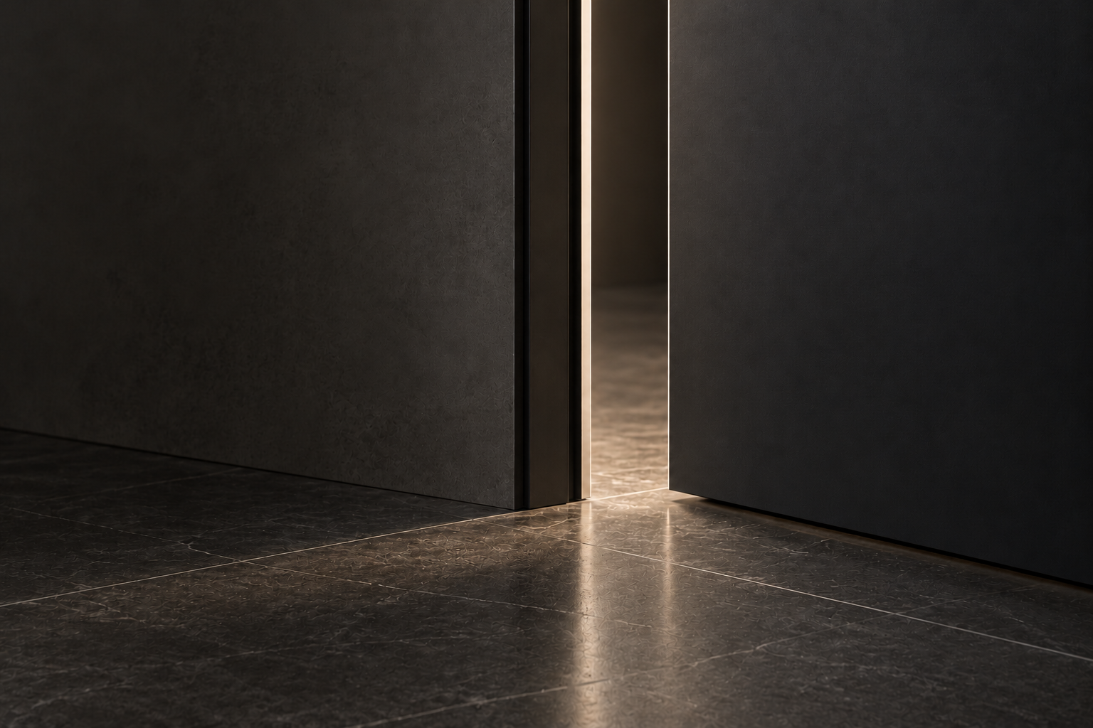The lower edge of a slightly open modern metal door, with a clear gap above the floor and light through the opening.