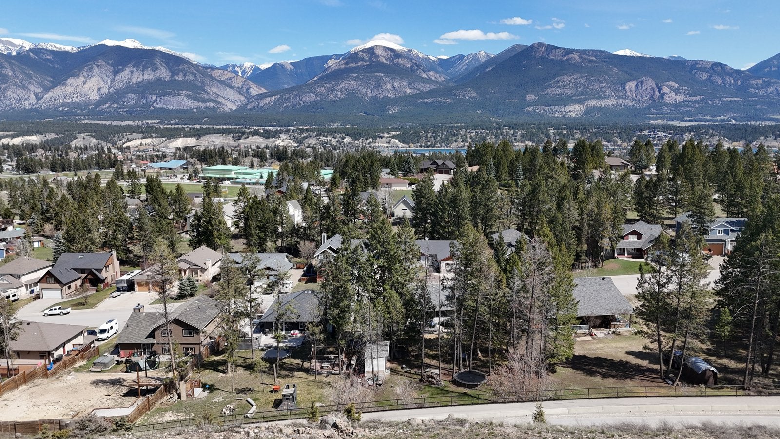 Aerial view of single-family homes in the Westridge neighbourhood of Invermere, BC, with the Rocky Mountains behind