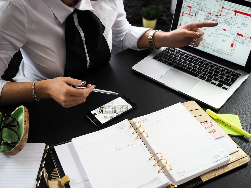 person pointing to laptop screen with CAD drawing of housing blueprints