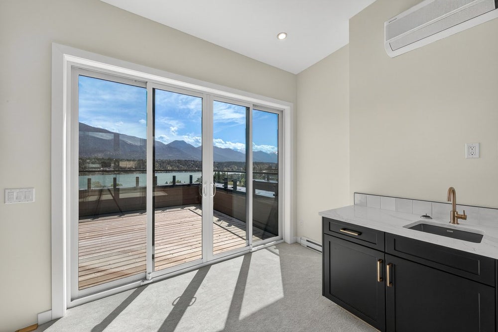 Vista Heights Invermere townhome sliding glass doors opening to rooftop deck overlooking Lake Windermere and Rocky Mountains
