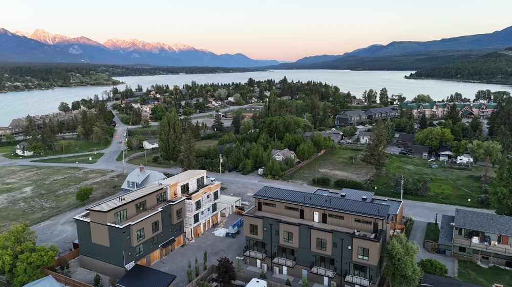 Aerial view of Invermere Townhome at Vista Heights with mountain and lake backdrop, showcasing luxury living in a scenic setting.