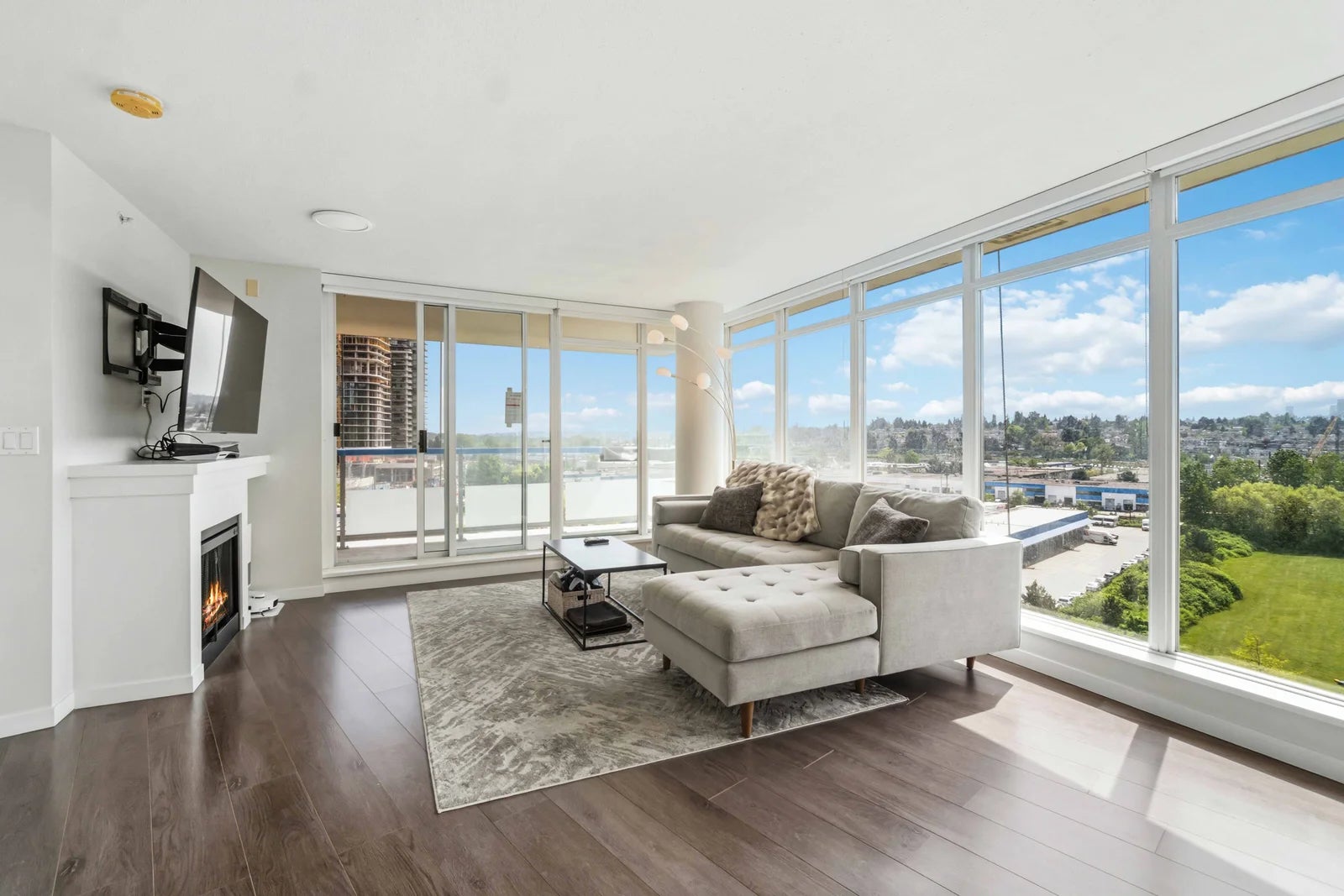 Metro Vancouver Rental Condo — Bright Corner Living Room with City Views Furnished corner living room in a Metro Vancouver rental condo with floor-to-ceiling windows and city views