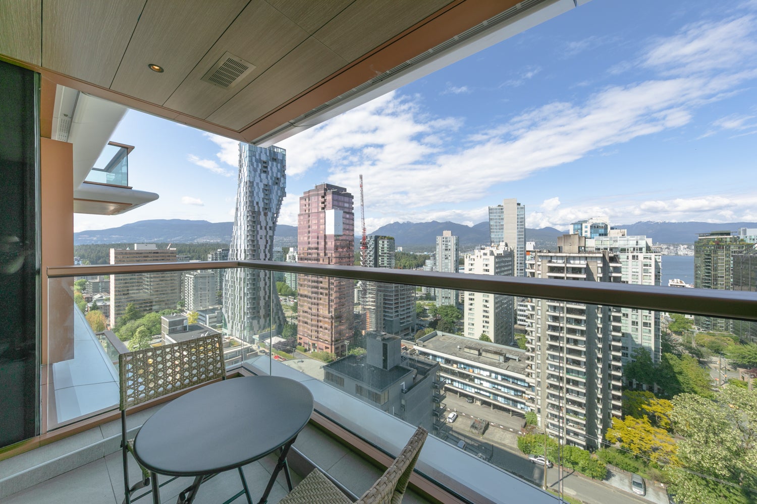 Modern Vancouver furnished rental condo balcony with skyline and mountain views in Downtown Vancouver 2026