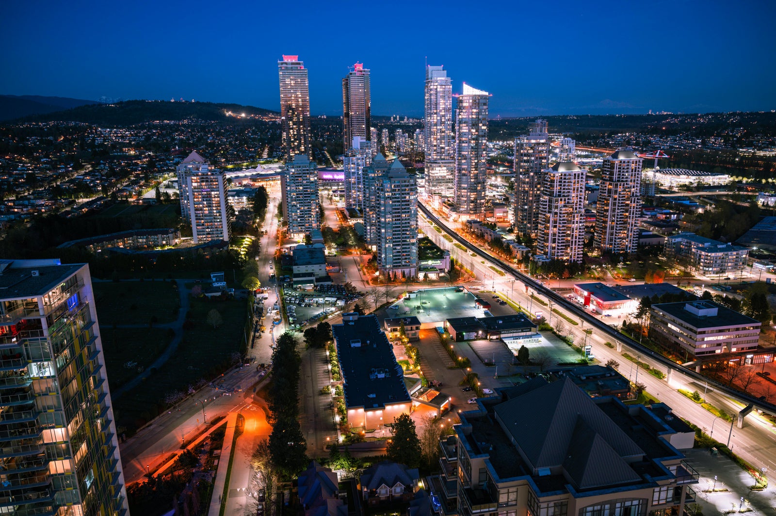 Metrotown Burnaby skyline at night with high-rise buildings - My Dream Realty property management Burnaby