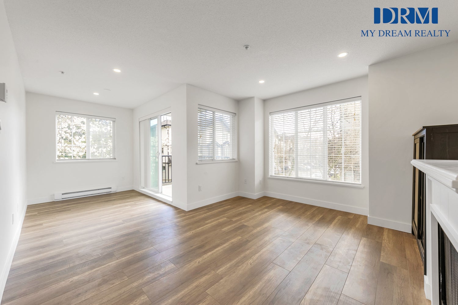 Maple Ridge Rental Property — Living Room 2026 Bright, empty living room with laminate flooring and large windows in a Maple Ridge rental propert