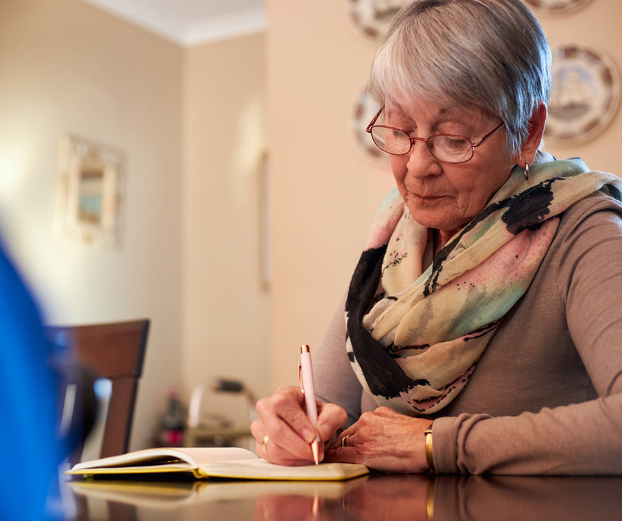 senior woman writing in notebook senior woman writing in notebook
