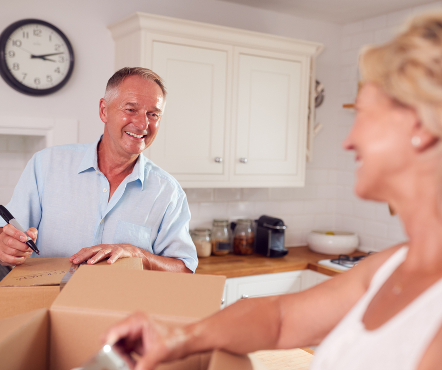 Senior couple labeling moving boxes